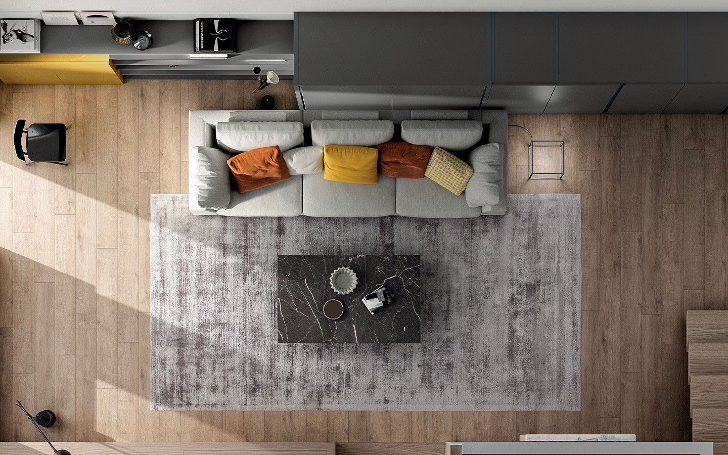 Vue en plan d'un salon moderne avec canapé gris, coussins colorés, table basse en marbre et parquet en bois clair, ambiance tonale