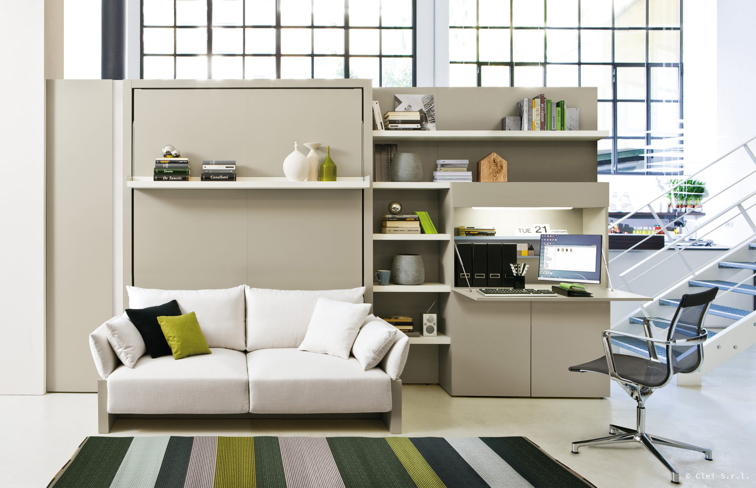 Canapé convertible avec bureau intégré, étagères et chaise de bureau moderne dans un espace lumineux. Design Clei Nuovoliola 10