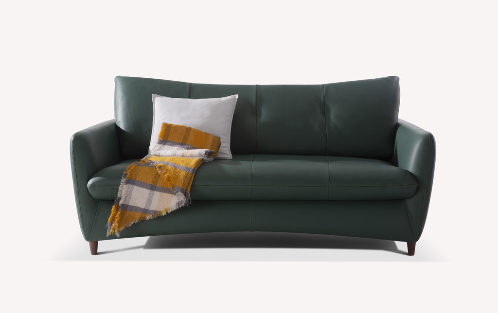 Canapé convertible en cuir vert forêt avec coussin blanc et plaid à carreaux jaunes et gris