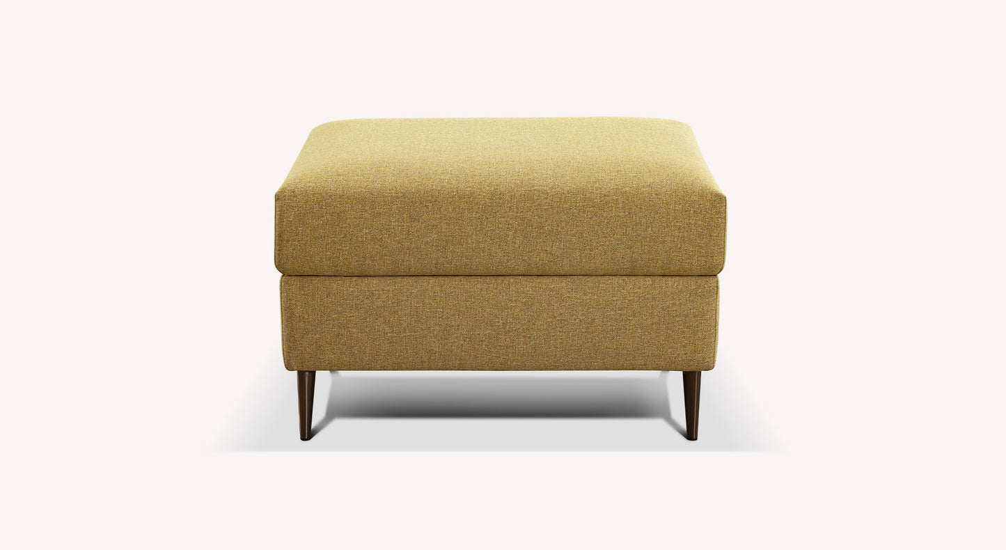 Pouf rectangulaire en tissu jaune moutarde, modèle Layne, avec pieds en bois foncé, sur fond blanc