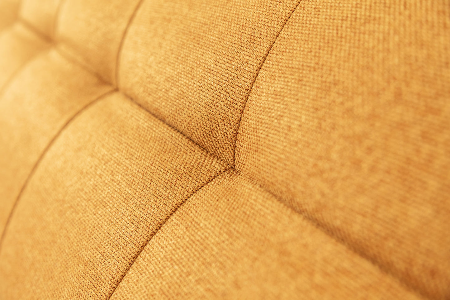 Gros plan sur le tissu texturé d'un canapé convertible Soho en couleur curry, modèle Austin