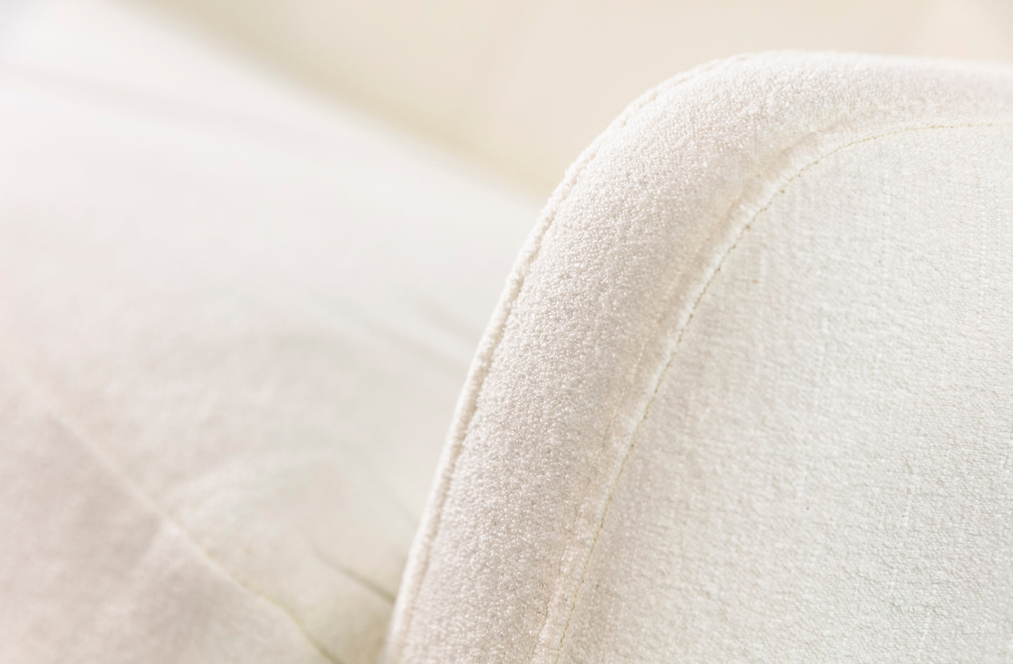 Accoudoir d'un canapé convertible en tissu blanc neige, revêtement douce et moelleuse