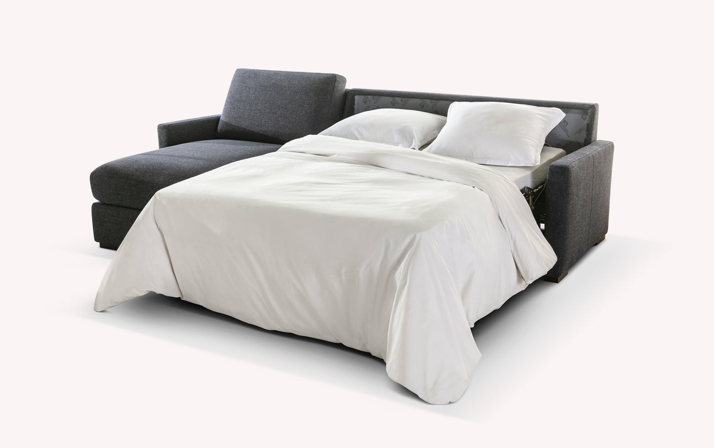 Canapé convertible en tissu gris foncé, modèle Lyon, ouvert en position lit avec draps blancs