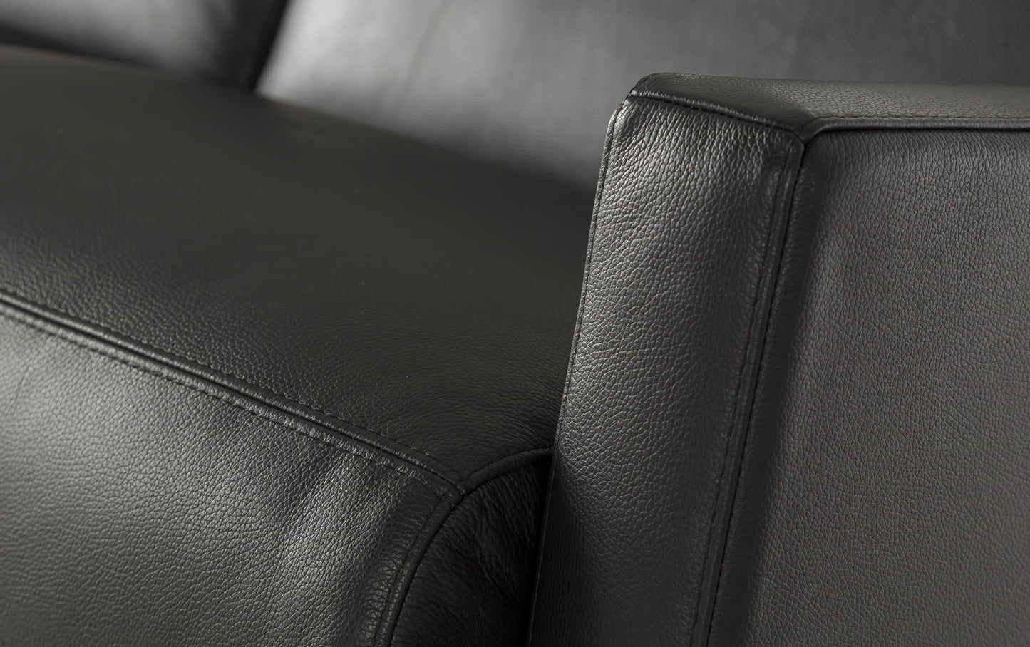 Accoudoir d'un canapé convertible en cuir noir luxueux, vue en gros plan