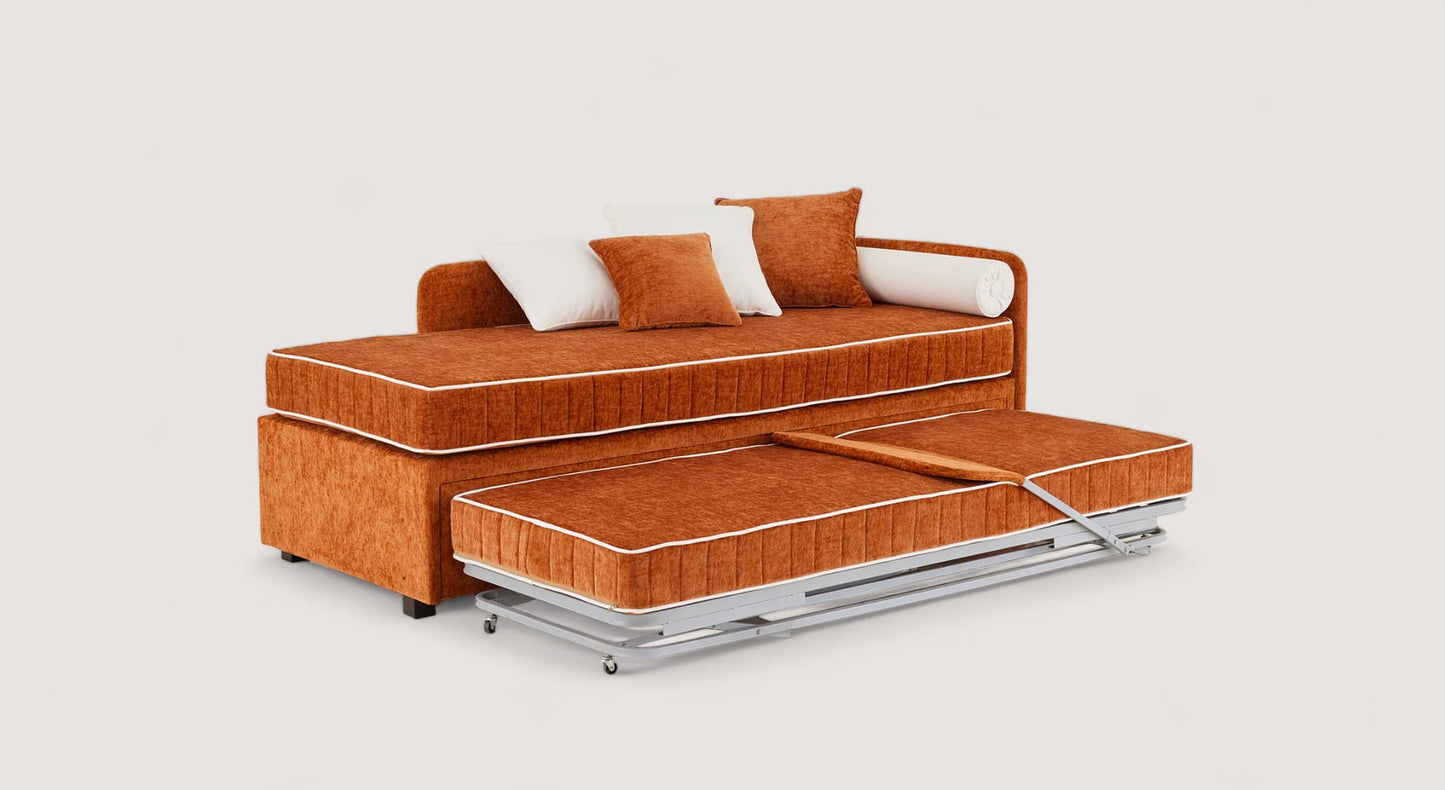 Lit gigogne Nolan en tissu orange avec matelas inférieur déplié, coussins assortis et roulettes pour un déplacement facile