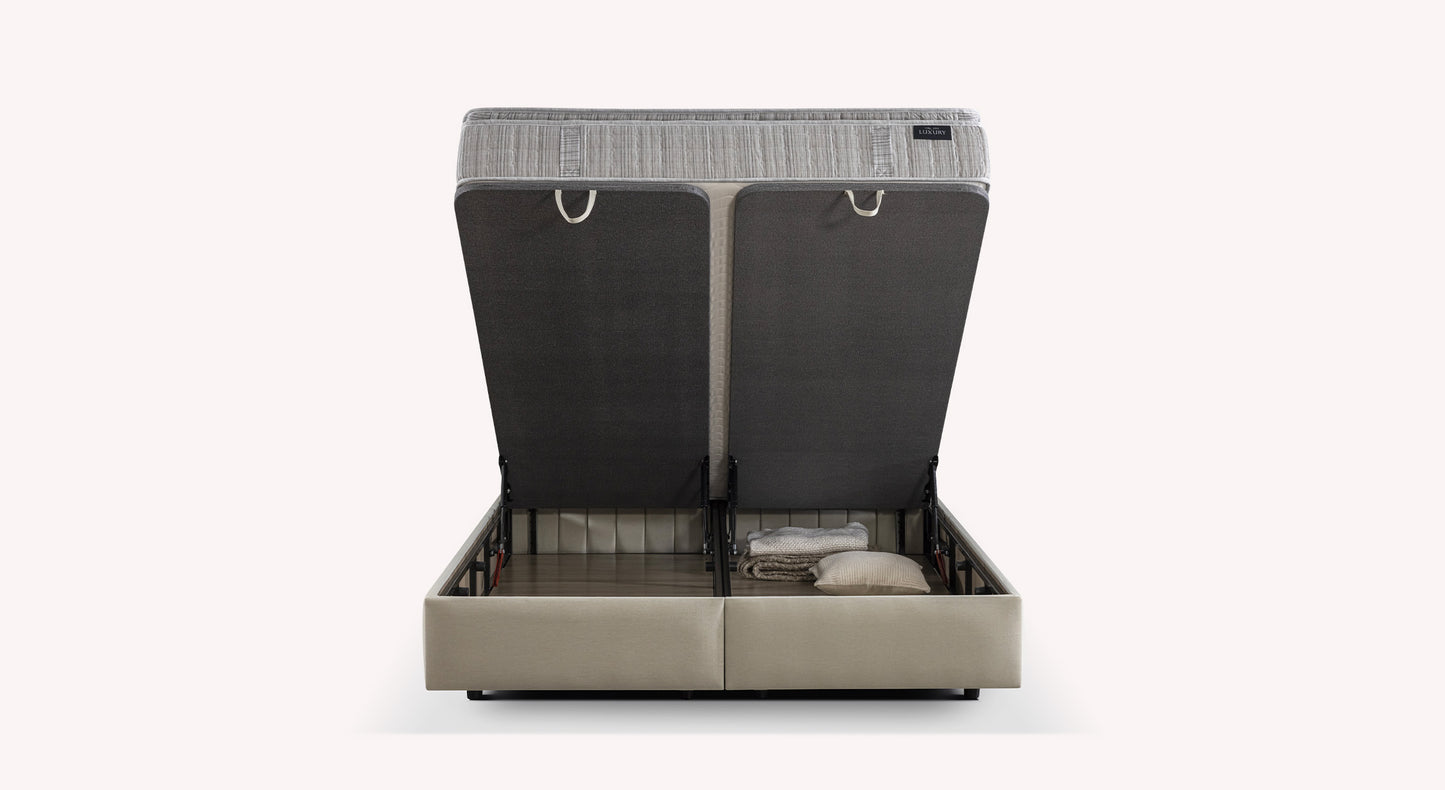 Lit coffre beige ouvert, montrant un espace de rangement avec des couvertures et des oreillers. Design moderne et fonctionnel