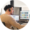Homme avec casque travaillant sur ordinateur, potentiellement en assistance technique ou support client