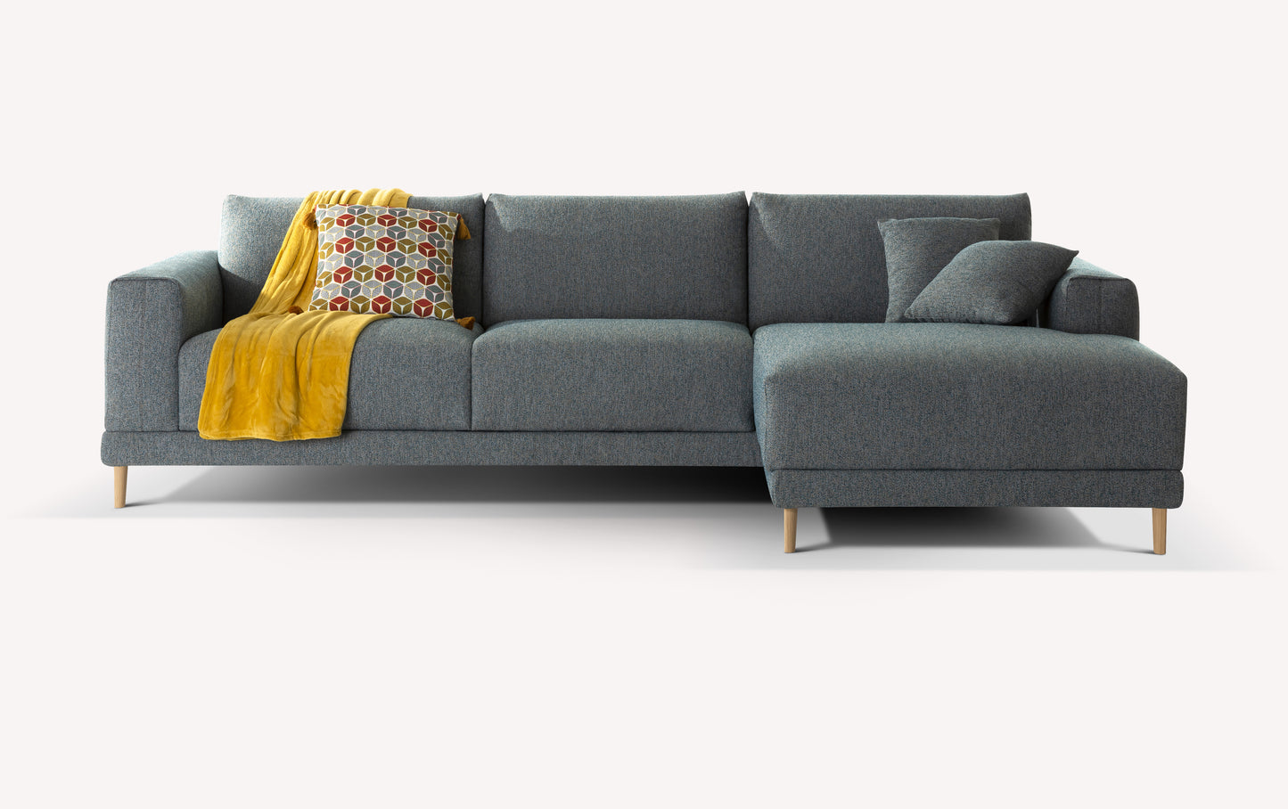 Canapé d'angle gris en tissu avec pieds en bois, décoré d'un plaid jaune et d'un coussin à motifs géométriques colorés