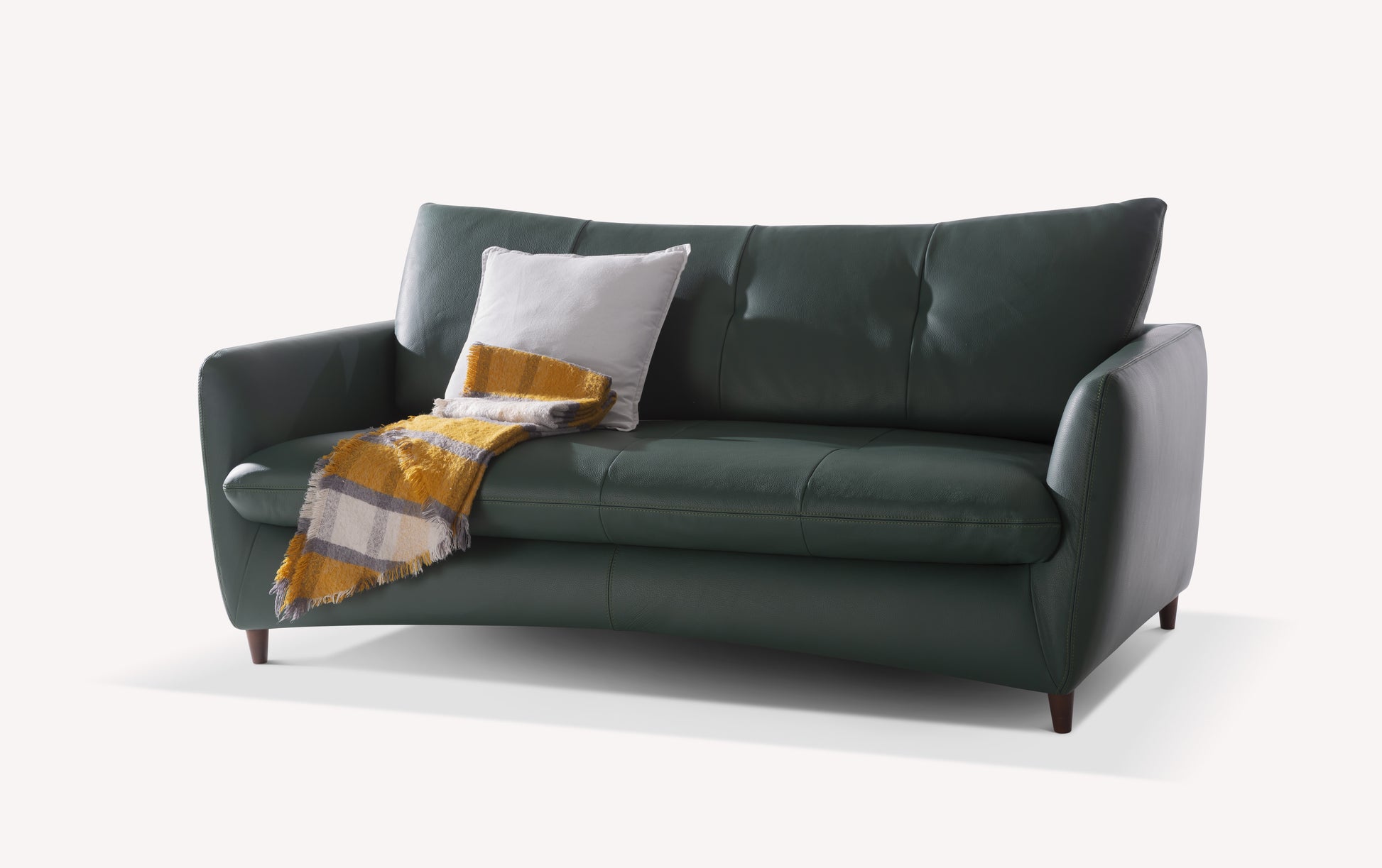 Canapé convertible en cuir vert forêt avec coussin blanc et plaid rayé jaune et gris