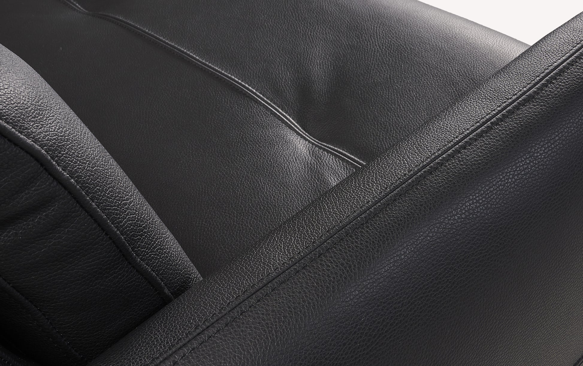 Gros plan sur le tissu en cuir noir d'un canapé convertible Bruce, montrant la revêtement luxueuse et les coutures détaillées