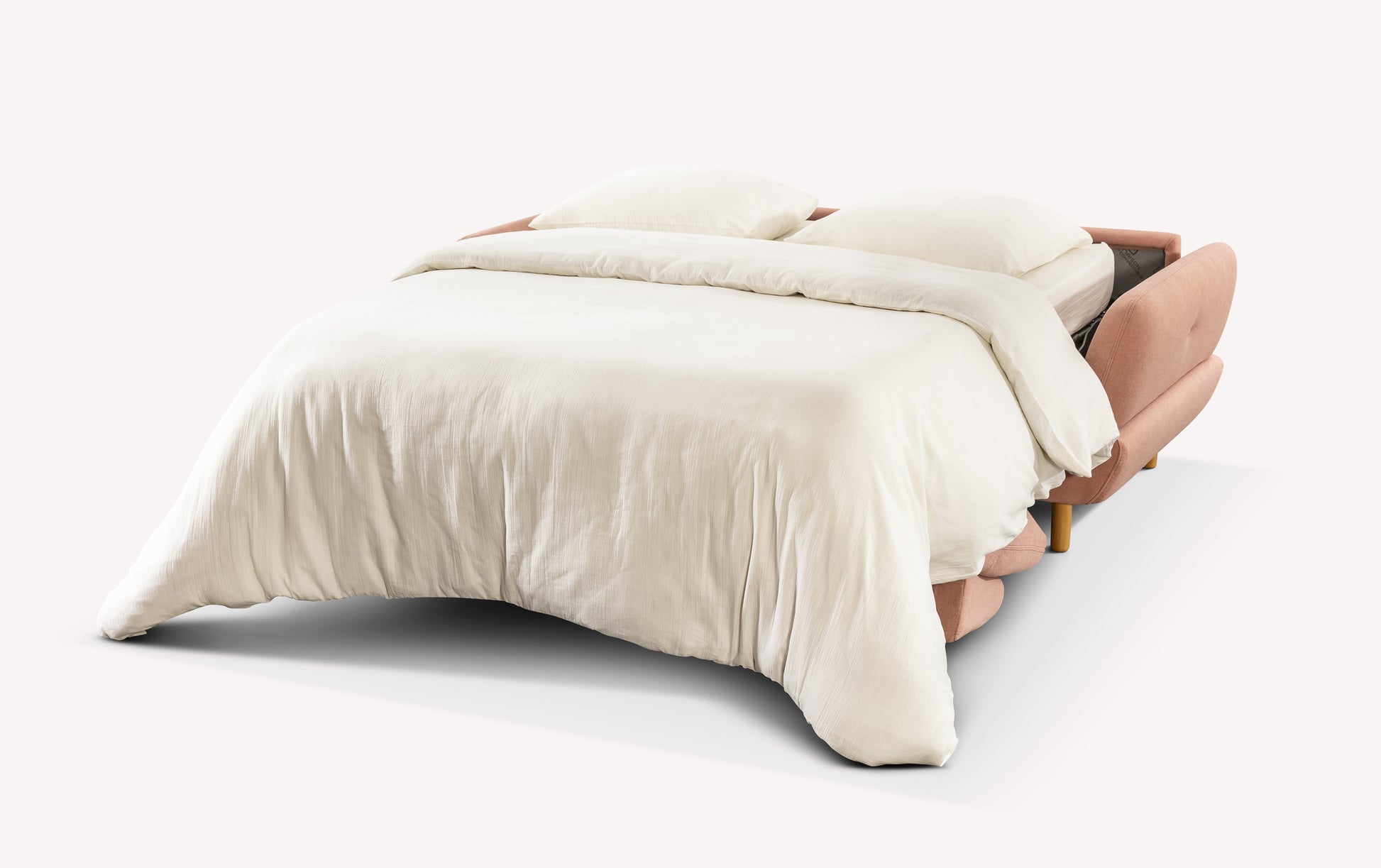 Canapé convertible ouvert en tissu rose, modèle Finn, avec draps blancs et coussins, sur fond blanc