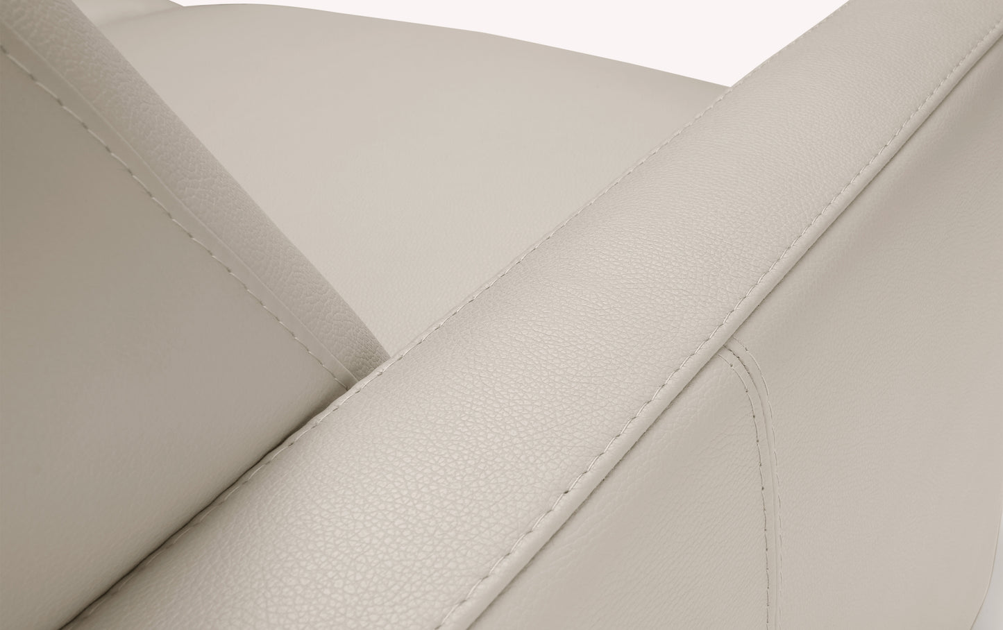 Gros plan sur le tissu en cuir avoine d'un canapé convertible de luxe, montrant les coutures et la revêtement